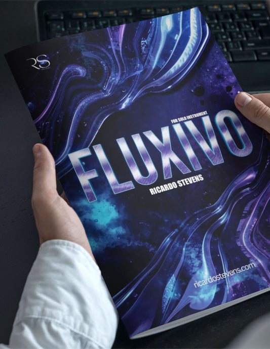 Book titled 'FLUXIVO' by Ricardo Stevens held by a person with a keyboard in the background